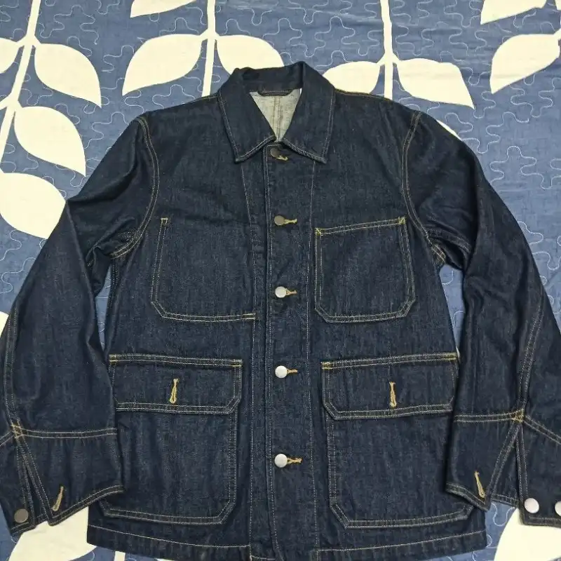 Denim jacket photographed flat on busy patterned background showing unprofessional product photography