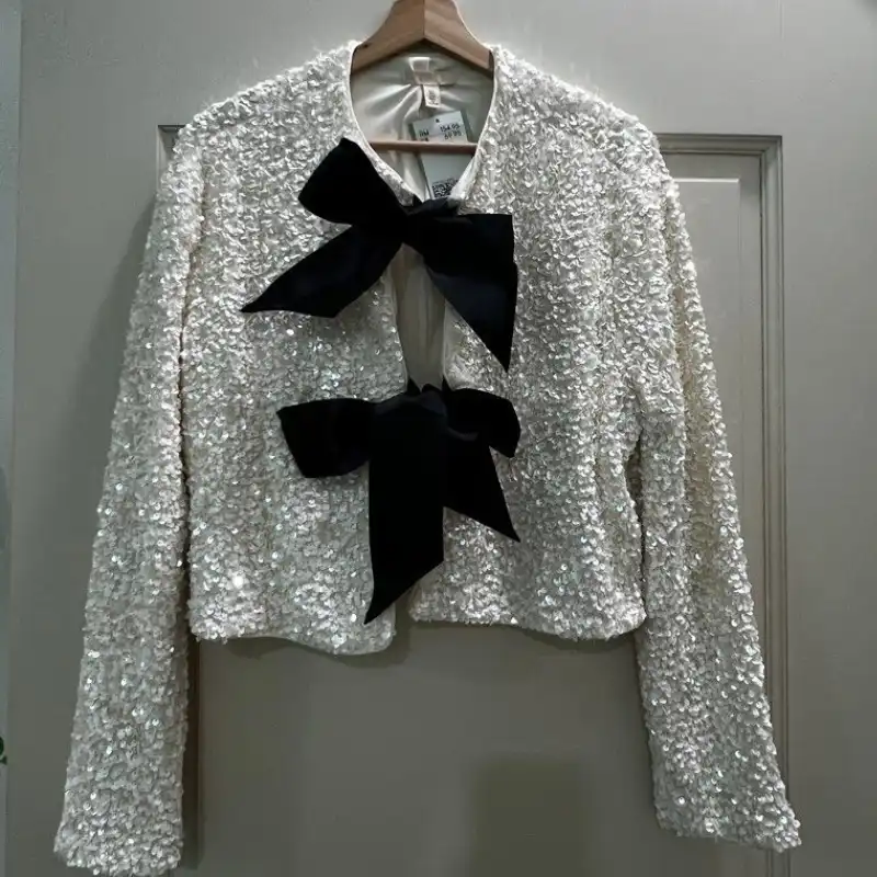 Sequin jacket on hanger with hidden collar structure and obscured neckline detail
